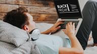 a man sitting on a bed using a laptop