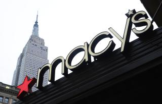 a "macy's" sign with the empire state building in the background