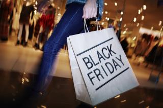 a person holds a shopping bag that reads "black friday"