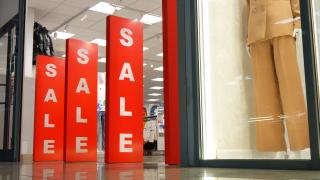 three red pillars at a store that read "sale"