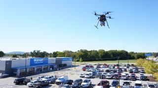 A drone hovers over a Walmart parking lot.