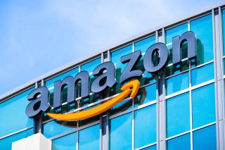 An Amazon logo on the side of a glass building.