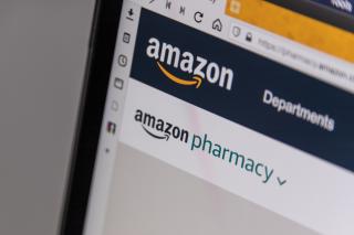 A laptop screen showing the Amazon Pharmacy logo.