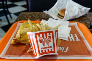 A photo of a orange Whataburger tray with a burger and french fries.