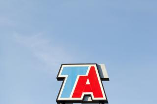 A logo for TA on top of a sign.
