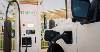 An electric vehicle is plugged in at a 7-Eleven 7Charge charger.