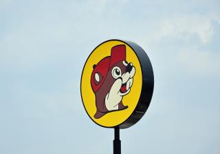 A sign of the Buc-ee's logo with a blue sky in the background.