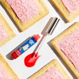 A photo of Claire's strawberry flavored lip gloss surrounded by Pop Tarts.