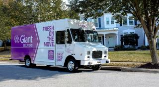 A Giant Delivers truck parked outside of a house.