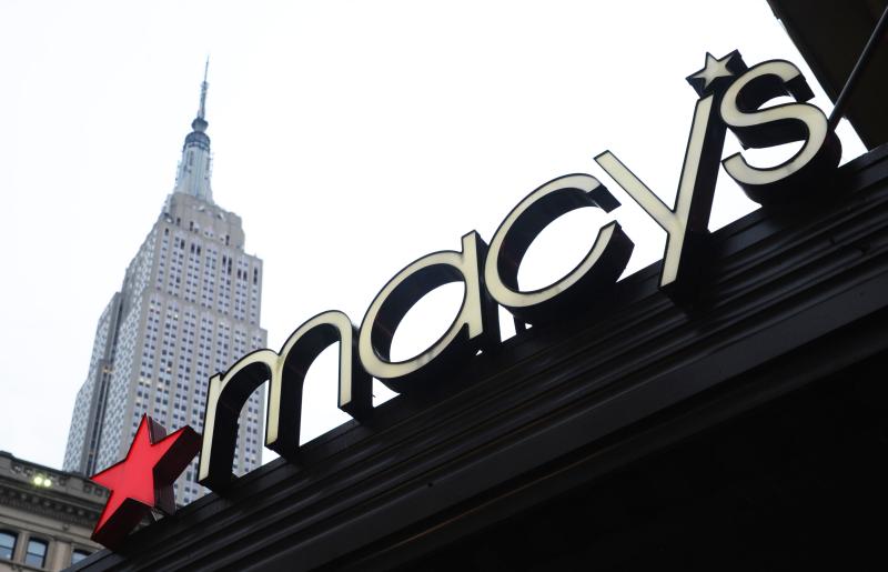 a "macy's" sign with the empire state building in the background