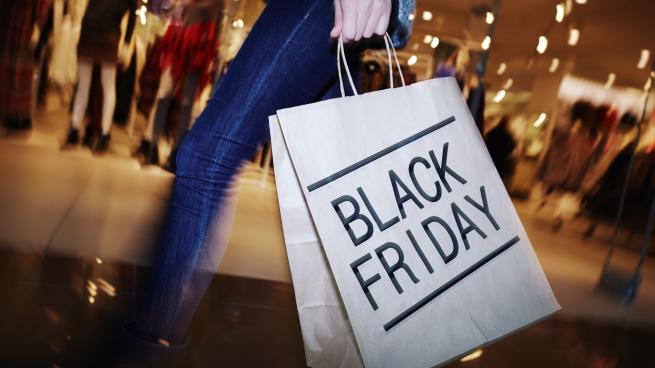 a person holds a shopping bag that reads "black friday"