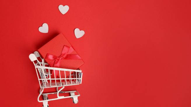 Valentine's Day graphic with hearts floating from a shopping cart on a red background.