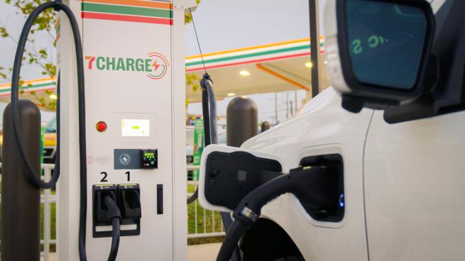 An electric vehicle is plugged in at a 7-Eleven 7Charge charger.