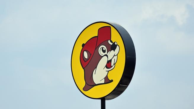 A sign of the Buc-ee's logo with a blue sky in the background.